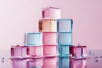 Colorful translucent ice cubes stacked in pyramid formation with water droplets on pink background for beverage and cooling concepts.