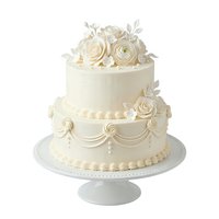 Elegant two-tier wedding cake with cream roses, pearl piping details, and decorative swags on white pedestal stand, isolated on white background for bakery, event planning, and celebration design use.