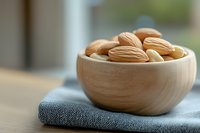 Fresh raw almonds in wooden bowl on kitchen counter for healthy snacking and cooking ingredients.