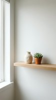 Minimalist wooden shelf with ceramic vase and succulent plant in terracotta pot near bright window, creating serene home decor and interior design inspiration.