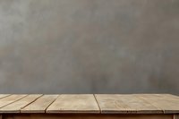 Rustic wooden table against neutral gray concrete wall background, perfect for product display or food photography.