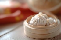 Steamed dumplings in bamboo steamer basket on wooden table with blurred Asian restaurant background for culinary and food service concepts.
