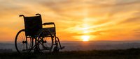 Empty wheelchair silhouetted against golden sunset sky, symbolizing hope, recovery, and resilience in healthcare and wellness contexts.
