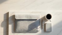 Minimalist workspace flat lay with laptop, notebook, coffee cup and geometric shadows on neutral beige surface for modern office design.