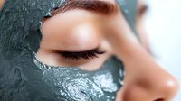 Young woman applying green clay facial mask for skincare routine and spa treatment at home for healthy glowing skin and natural beauty wellness.