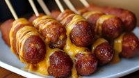 Grilled meatballs on wooden skewers with golden glaze served on white plate. Perfect for barbecue parties, appetizers and casual dining menus.