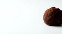 Whole coconut with brown fibrous husk isolated on white background for tropical food and natural ingredient concepts.