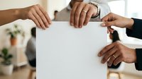Diverse group of professionals holding blank white paper together in office setting, symbolizing teamwork, collaboration, unity and shared business goals.