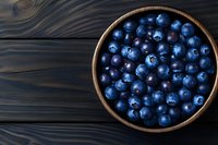 Fresh ripe blueberries in wooden bowl on dark rustic table, healthy organic superfood antioxidant rich berries for cooking baking smoothies nutrition.