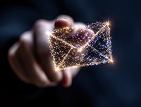Glowing digital envelope made of light particles and connection lines floating above hand on dark background, representing electronic mail communication technology.