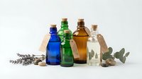 Colorful glass bottles with cork stoppers containing essential oils arranged with lavender sprigs and eucalyptus leaves on white background for aromatherapy.