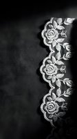 White lace border with floral rose pattern on dark background, suitable for wedding invitations, textile design, and decorative overlays.