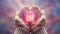 Cupped hands holding a glowing crystal heart with radiant light rays, symbolizing love, healing, and spiritual energy for wellness concepts.