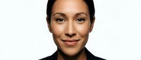 Professional mixed-race businesswoman with confident smile wearing black blazer against white background for corporate headshot and marketing materials.