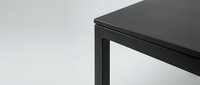 Modern black metal table corner detail with clean lines and minimalist design for contemporary interior spaces and furniture catalogs.