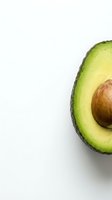 Fresh ripe avocado half with pit on white background isolated for healthy food design and culinary projects.