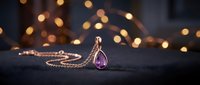 Elegant amethyst teardrop pendant necklace on dark surface with warm golden bokeh lights, luxury jewelry and accessories for fashion, beauty, and lifestyle marketing.