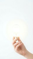 Hand holding glowing light bulb against white background representing bright ideas, innovation, creativity, inspiration and eureka moments for business solutions.