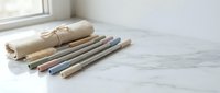 Eco-friendly reusable drinking straws made from natural materials with canvas storage pouch on marble surface for sustainable lifestyle.