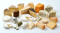 Assorted gourmet cheese collection featuring various textures and flavors including aged cheddar, brie, gouda, blue cheese and artisanal varieties on white background.