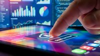 Hand touching a glowing tablet screen with colorful app icons, charts, and data analytics dashboard in the background for tech concepts.