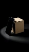Smartphone with blank screen leaning against kraft cardboard box on dark background, suitable for product mockups, packaging design, and e-commerce presentations.
