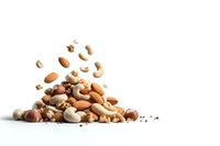 Mixed nuts and seeds scattered and falling in artistic composition on white background, isolated food photography for healthy eating and snack concepts.