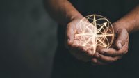 Hands holding glowing geometric sphere with golden light rays creating mystical energy orb for spiritual healing and meditation concepts.