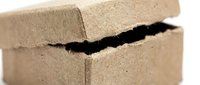 Cracked cardboard box showing structural damage and wear, perfect for shipping damage claims, quality control documentation, and packaging failure concepts.