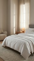 Serene bedroom interior with white bedding, cream curtains filtering natural light, wooden nightstand with warm lamp, and neutral upholstered chair for home decor.