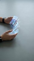 Hands holding transparent smartphone with holographic digital interface display, futuristic technology concept for innovation and digital transformation applications.