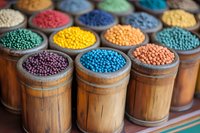 Colorful natural dye pigments and beads in wooden bamboo containers at traditional market, vibrant powder colors for textile and craft production.