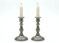 Pair of vintage pewter candlesticks with cream pillar candles isolated on white background, ready for home decor design projects and product mockups.