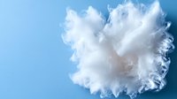 Fluffy white cotton ball texture on blue background, macro photography closeup showing delicate fibers and soft texture details for cosmetic and skincare concepts.