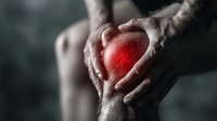 Man holding painful knee with red glow highlighting inflammation area, concept of joint pain, arthritis, sports injury and medical condition.