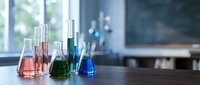 Laboratory glassware with colorful chemical solutions on wooden table in modern research facility for scientific experiments and analysis.