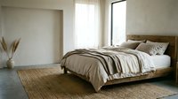 Minimalist bedroom interior with wooden platform bed, neutral bedding, natural light from windows, and woven area rug for home decor and interior design projects.