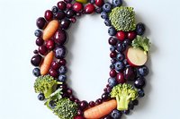Letter U made from fresh fruits, vegetables and berries on white background. Healthy eating concept with natural ingredients arranged in typography.