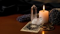Mystical altar setup with burning candle, crystal quartz, tarot cards, and sacred geometry symbols for spiritual meditation and divination practices.