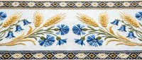 Traditional embroidered border with wheat stalks and blue cornflowers on white fabric, featuring geometric trim pattern for textile and craft projects.