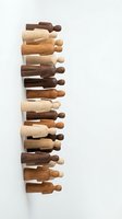 Wooden rolling pins in various natural wood tones stacked vertically on white background, showcasing different finishes and grain patterns for baking and culinary design projects.