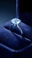 Sparkling diamond engagement ring in luxury blue velvet box with dramatic lighting creating brilliant reflections for jewelry advertising and wedding concepts.