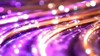 Vibrant purple and orange light trails with glowing bokeh effects create dynamic motion streaks against dark background, suitable for technology and fiber optic concepts.