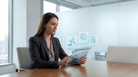 Professional businesswoman using digital tablet in modern office with floating technology icons representing digital transformation and connectivity solutions.