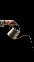 Hand holding metal watering can pouring water, isolated on transparent background. Ready for gardening, agriculture, and botanical design projects, t-shirts, stickers, and print-on-demand products.