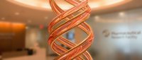 Young female scientist with light skin tone examining glowing DNA helix model in modern laboratory setting, conducting genetic research and biotechnology analysis for medical advancement.