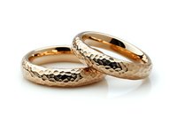 Pair of rose gold wedding bands with hammered texture pattern on white background, luxury jewelry photography for bridal and engagement concepts.