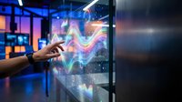 Businessman touching futuristic holographic display with colorful data visualization and digital interface in modern office environment for technology presentations.
