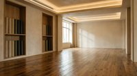 Elegant empty room with warm hardwood floors, built-in shelves, and soft cove lighting, showcasing minimalist interior design for real estate and renovation concepts.