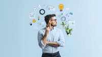 Young Caucasian businessman in glasses thinking with creative business icons floating around head, innovation concept on light blue background, contemplative pose.
